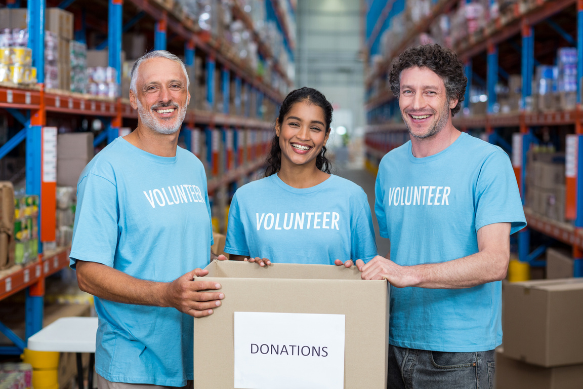 Portrait of three volunteers holding a donations box